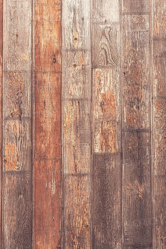 A close-up view of rustic wooden planks with varying shades of brown and gray. The texture shows natural imperfections and grain patterns