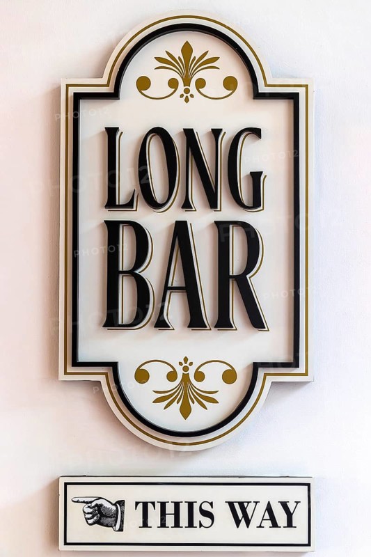 Decorative signboard directs guests to the Long Bar birthplace of the Singapore Sling cocktail, Raffles Hotel Singapore
