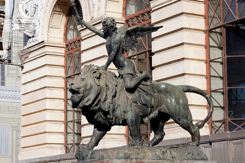 Winged boy riding on a lion, allegorical bronze sculpture in front of the Palazzo della Borsa, Piazza Giovanni Bovio, Naples, Province of Campania, Italy