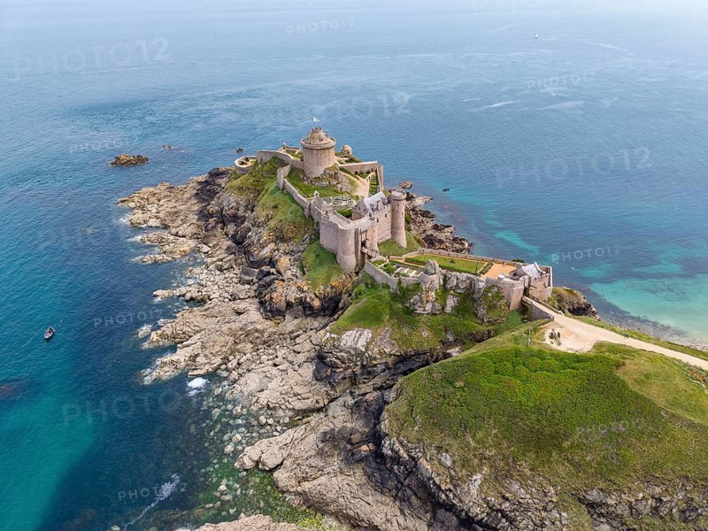 Aerial view of the historic rock castle Fort la slat, Château de la Roche Goyon on a rocky headland on the Emerald Coast, surrounded by the turquoise Atlantic Ocean, Plevenon, Côtes-d'Armor department, Brittany region, France