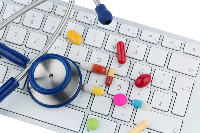 Tablets on keyboard, symbolic photo for online pharmacies and drug costs, Austria