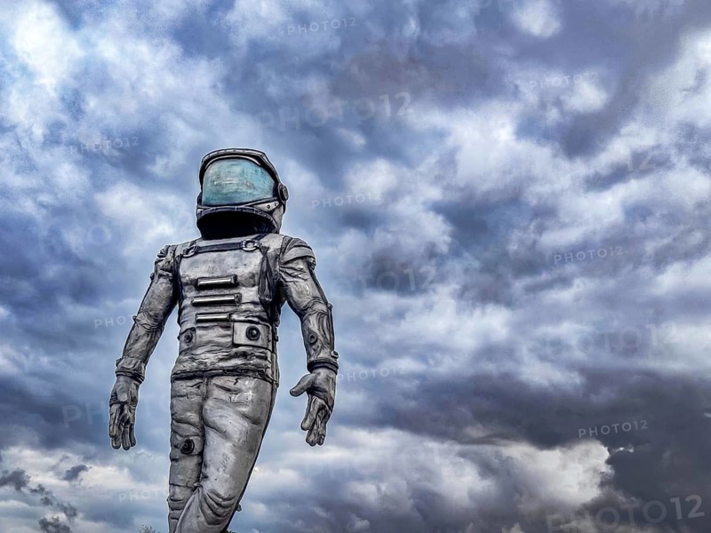 Antalya, Turkiye - 25.10.2025: An astronaut in a space suit stands against a cloudy sky. The scene conveys themes of exploration and technology