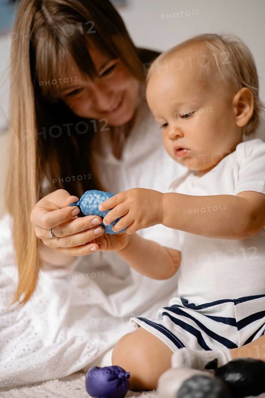 Mother and baby engaging with a blue toy, sharing a moment