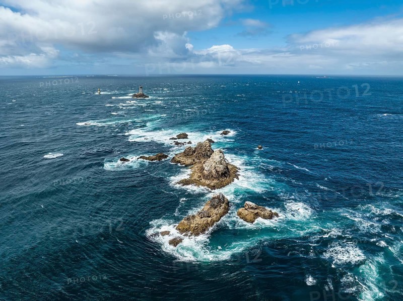 Aerial view of the wild foaming sea at Pointe du Raz with the offshore Phare de la Vieille lighthouse on a rocky island in the rough sea road, Raz de Sein, Pointe du Raz, Plogoff, Quimper, Finistère, Brittany, France