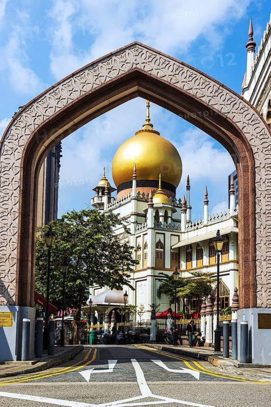 Looking through an archway to the Golden dome and minarets of Masjid Sultan or Sultan Mosque rebuilt in 1932 to designs by Denis Santry rises above Kampong Glam, Singapore
