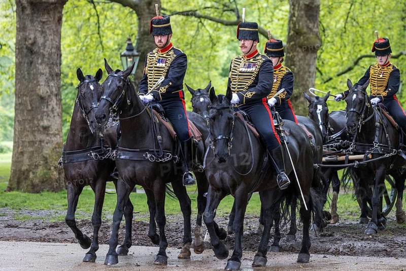 Ceremonial riders of the King's Troop Royal Horse Artillery lead black horses in dress uniform through Green Park, London