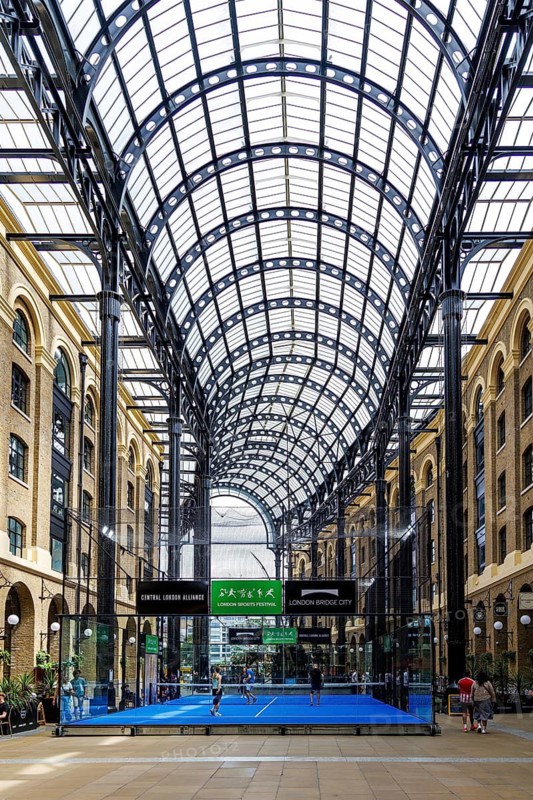 Sunlight filters through the barrel-vaulted glass and iron roof of Hay's Galleria, a former Thames wharf once nicknamed the Larder of London, now enclosing shops and a padel court in the redeveloped Victorian warehouse complex on the South Bank, London, England, United Kingdom