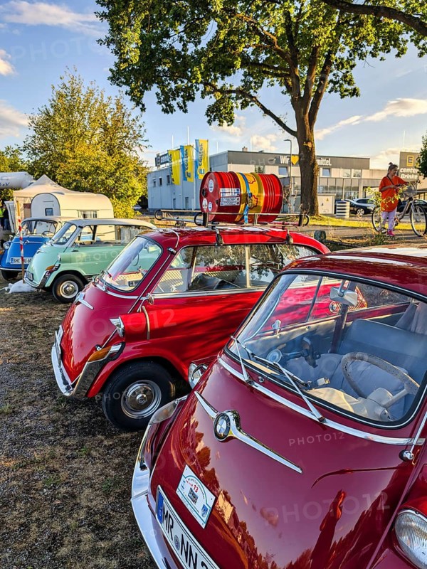 Different colored BMW Isetta park side by side, annual meeting 2026, distinctive small car with front door, cult, smooch ball, historic cultural property, Holzminden, Weser Hills, Germany