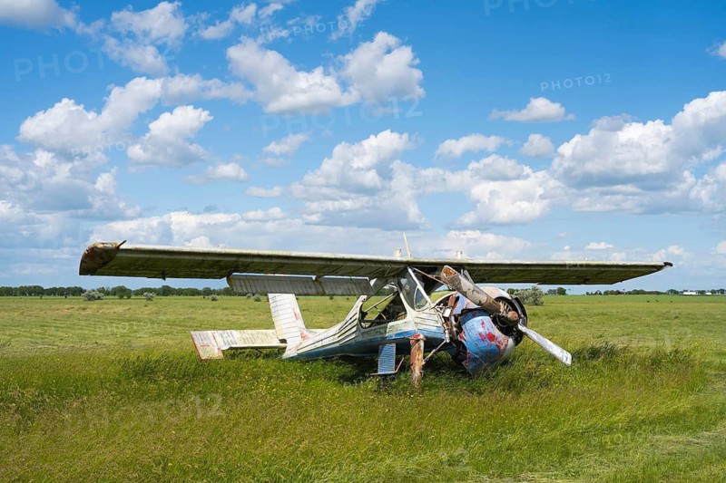 An abandoned, damaged aircraft is lying in a field under a blue sky with clouds, PZL-104 Wilga multi-purpose aircraft, abandoned airport, Ceadir-Lunga, Ceadîr-Lunga, Chadyr-Lunga, Taraclia district, Gagauzia autonomous region, Republic of Moldova, Moldova