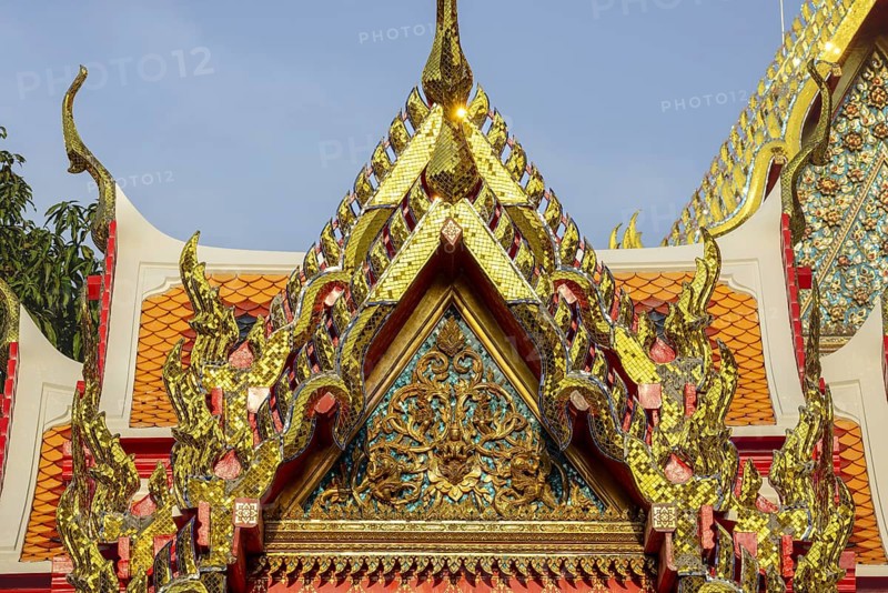 Golden mosaic ornaments rise like flames to heaven carried by Chofa and Bai Raka on the ornate pediment of the Wat Pho Temple, a brilliant detail of Thai religious architecture, Wat Pho, Bangkok, Thailand