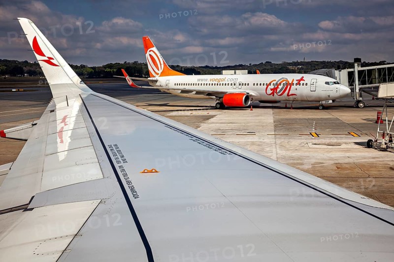 View from the plane at an airport where another aircraft is parked at the terminal, airplanes on the runway at Petrolina airport in Brazil