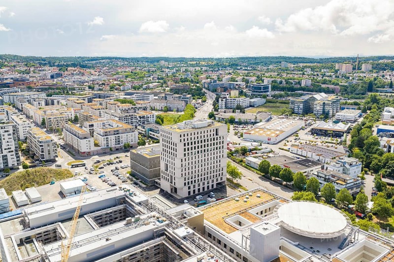 City view from above with modern buildings, roads and a clear sky on the horizon, new hospital building, Böblingen airfield, Germany