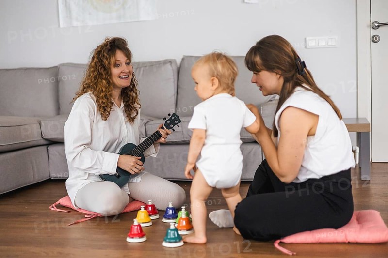 Playful music session with a toddler, a woman, and colorful instruments