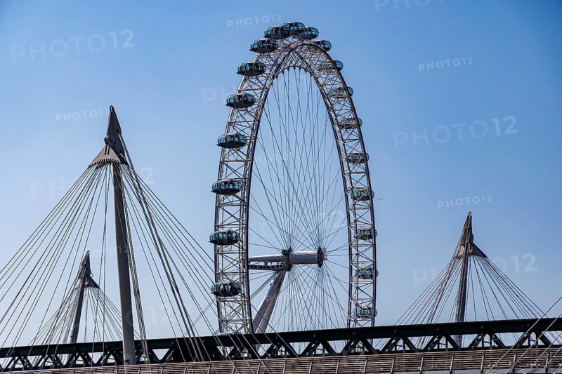 The London Eye observation wheel rises behind the suspension cables of the Golden Jubilee Bridges on the South Bank, London, England, United Kingdom
