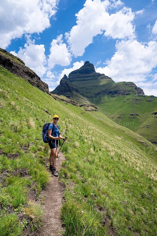 Female hiker on the hiking trail to Cathedral Peak, Green Mountains and Hills, Drakensberg Mountains, KwaZulu-Natal, South Africa