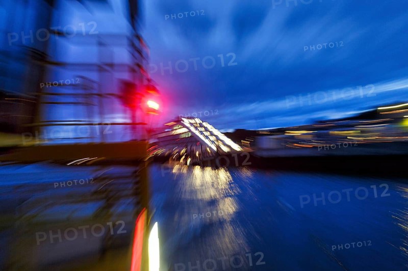Red light signal on harbor ferry, view of illuminated Dockland office building, harbor tour at dusk, dynamic, abstract mopping effect, river, Elbe, Hamburg, Germany
