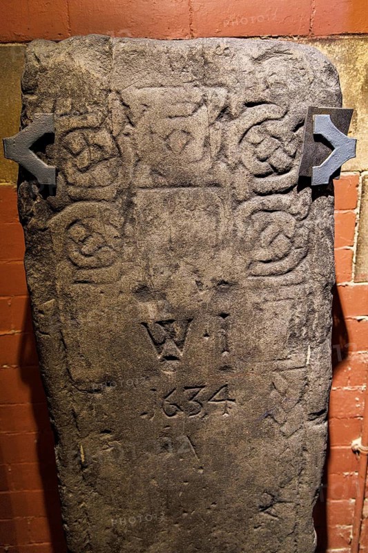 Recumbent grave slab decorated with carved roundel patterns and initials W I dated 1634, part of the early medieval Govan Stones collection, Glasgow, Scotland, United Kingdom