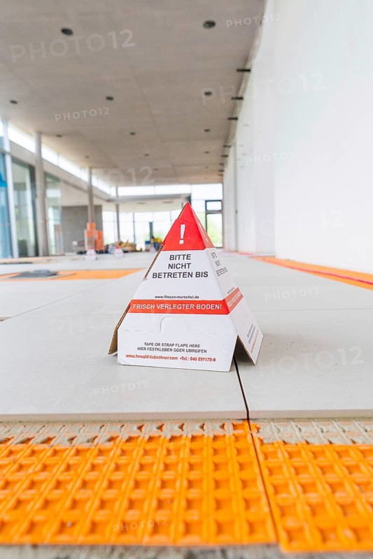Laying tiles, in the foreground a warning sign in a construction site interior, car park construction, Calw, Germany