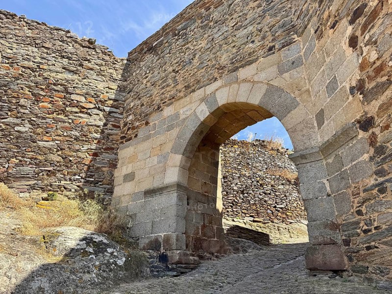 Sturdy stone arch as access between stone walls, medieval flair, Monsaraz, Évora, Portugal