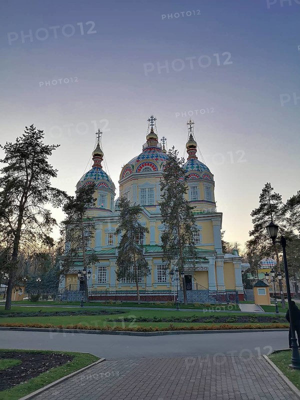 ALMATY, KAZAKHSTAN, NOVEMBER 8, 2019: Ascension Cathedral in Park of 28 Panfilov Guardsmen in Almaty Kazakhstan, Ornate church with colorful domes surrounded by trees and a pathway at dusk, Almaty, Kazakhstan