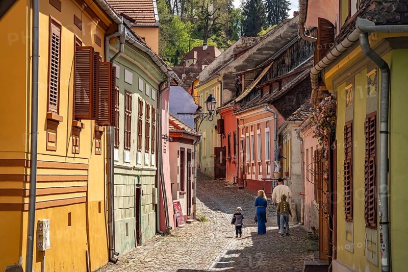 Tourists among the colorful houses of the old town of Sighisoara or Sighi?oara, Transylvania, Romania