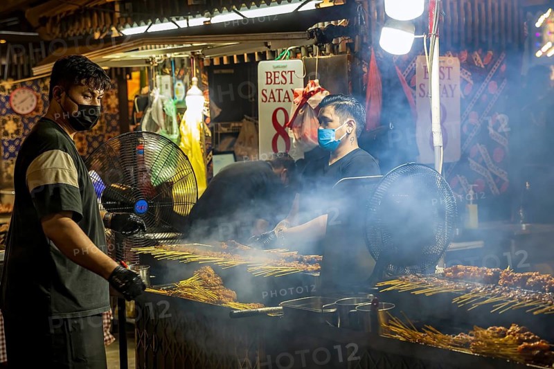 Chef grilling satay skewers over charcoal at Satay Street street-food night market, Lau Pa Sat, Singapore