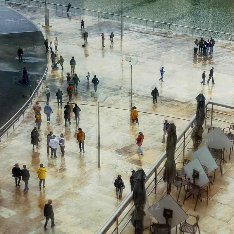 View of a crowd of people with window reflection and movement