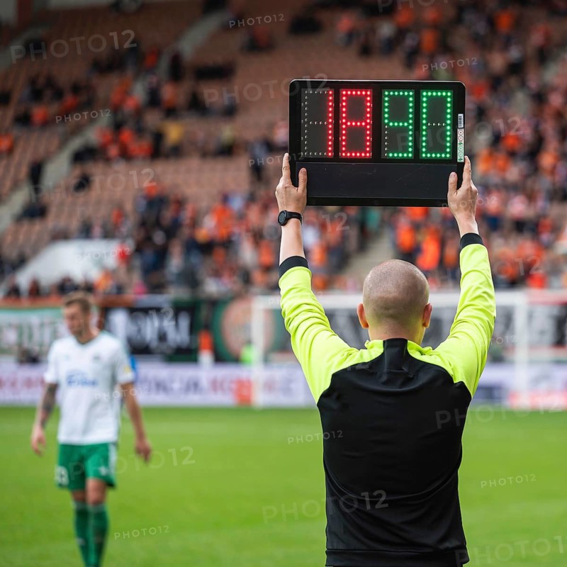 Team manager man shows players substitution during football match in Lubin, Poland