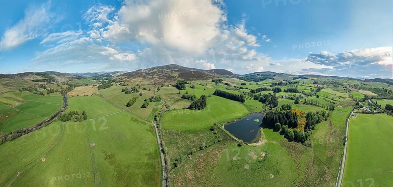 Aerial panorama photo of an agricultural landscape with meadows and pastures at the border of the Cairn Gorm National Park in Scotland, UK