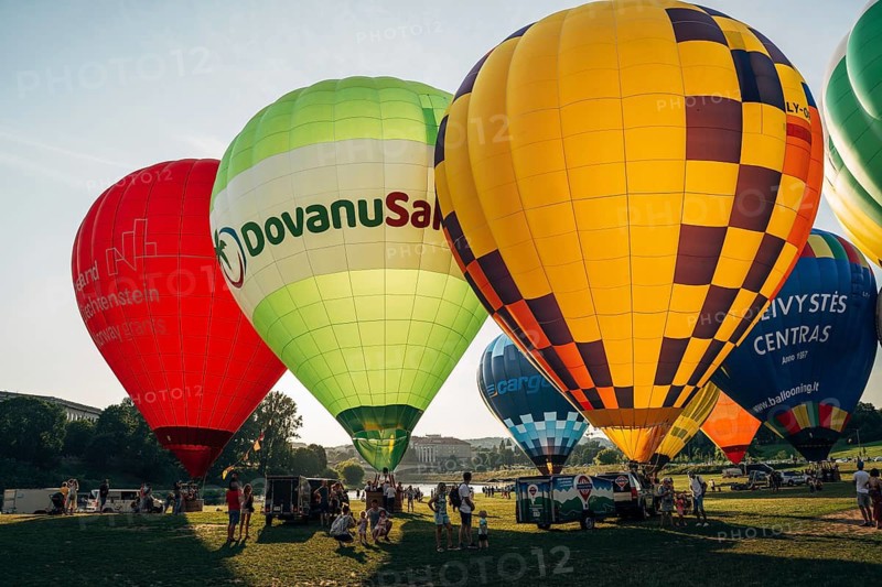 Vilnius, Lithuania, 08 05 2022: Hot air balloons in Vilnius. Multi-colored hot air balloons on the ground before takeoff. Lots of balloons in the field, A group of colorful hot air balloons preparing to take off on a sunny day, Vilnius, Lithuania
