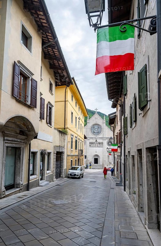 Street with Italian flags, Duomo di Santa Maria Assunta church in the back, Gemona del Friuli, Friuli-Venezia Giulia, Italy