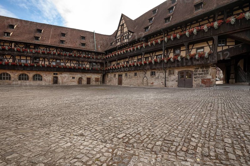 20 August 2026, The historic cobblestone courtyard of Alte Hofhaltung with the Bamberg Cathedral spire visible in Bamberg, Germany