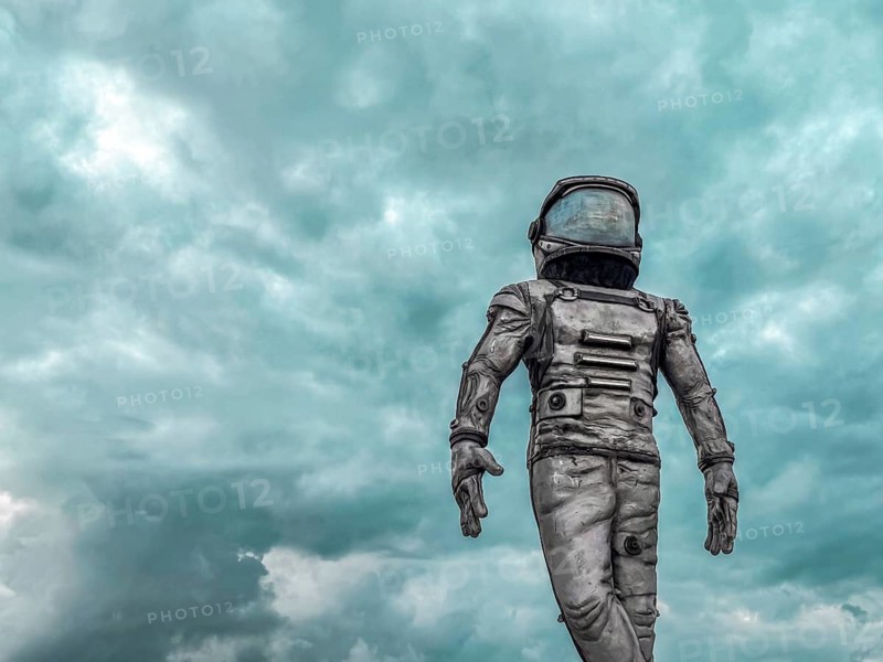 Antalya, Turkiye - 25.10.2025: An astronaut in a spacesuit walks on a barren landscape under a cloudy sky. The scene conveys themes of exploration and the unknown