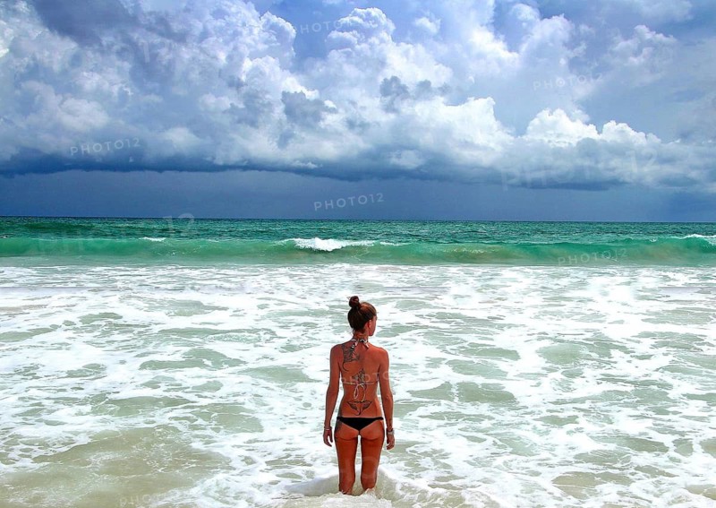 Woman on Phuket beach in bikini, rainy season, Thailand
