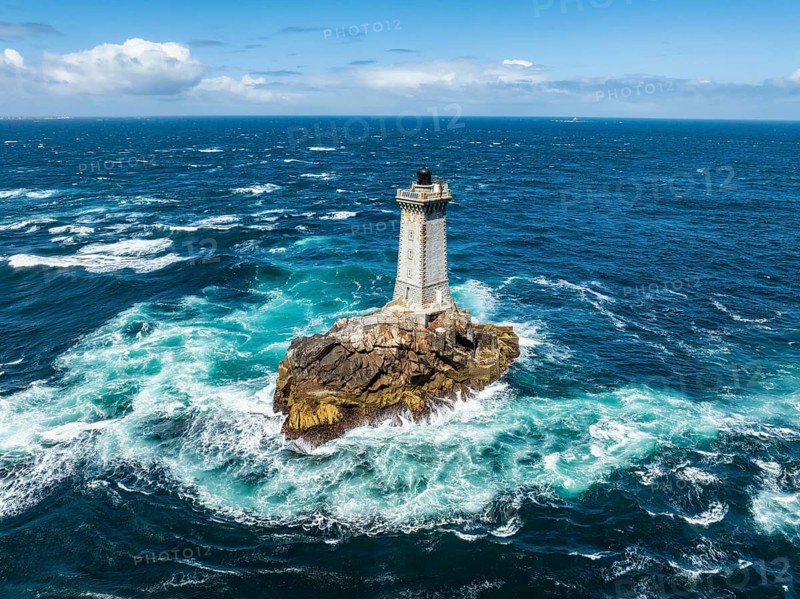 Aerial view of the historic Phare de la Vieille lighthouse, built from 1882 to 1887 on a rocky reef in the midst of stormy, foaming ocean waves, Raz de Sein strait, Pointe du Raz, Plogoff, Quimper Arrondissement, Finistère, Région Bretagne, France
