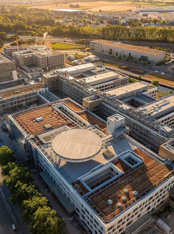 Industrial complex with modern buildings and green trees from a bird's eye view, construction site of the new airfield clinic, Böblingen, Germany