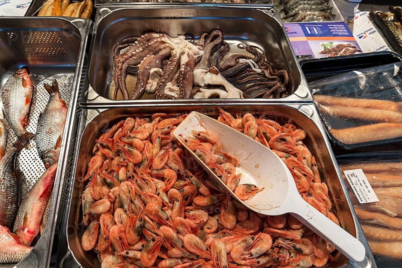 Prawns (Brachyura), with a squid (Coleoidea) in the background, at a weekly market market in Enschede, the Netherlands