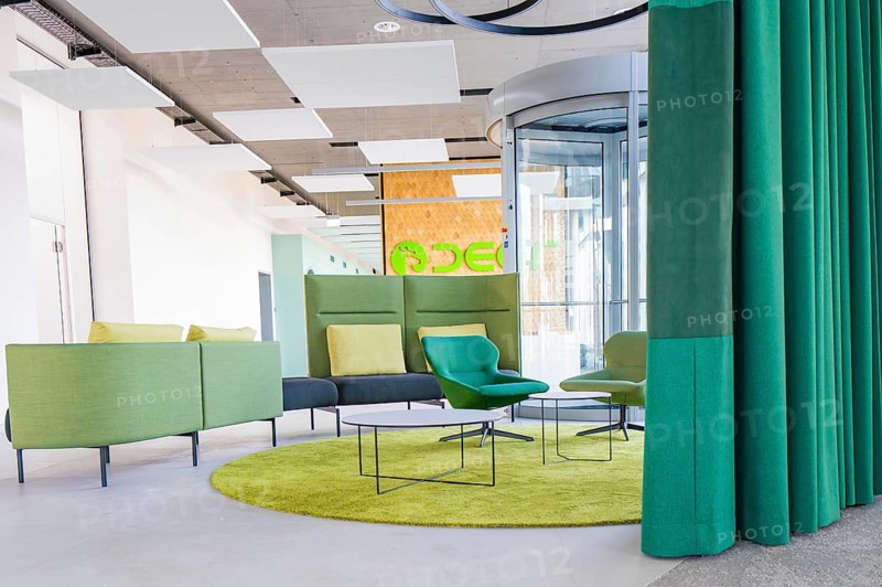 Modern sitting area with colorful furniture and a glass lift