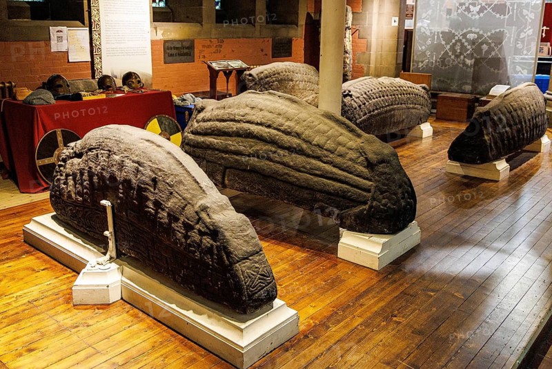 Five carved hogback gravestones of Anglo Scandinavian Viking Age design displayed together in Govan Stones collection inside Govan Old Parish Church, Glasgow, Scotland, United Kingdom