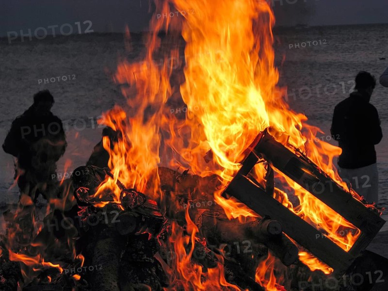 Easter bonfire, bonfire on the beach, bright flames and burning wood, dark silhouettes of tourists at dusk, North Sea, Wenningstedt, Sylt, Germany