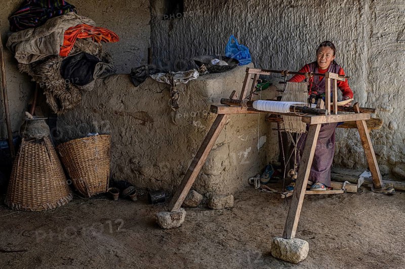 A woman works on her loom, traditional clay house, Choser, Mustang, Upper Mustang, former kingdom, Himalayas, Nepal
