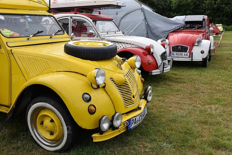 Three classic Citroën 2CV cars are standing side by side in a meadow, vintage Citroën 2CV6 cars at a duck meeting in Kropp, Schleswig-Holstein, Germany