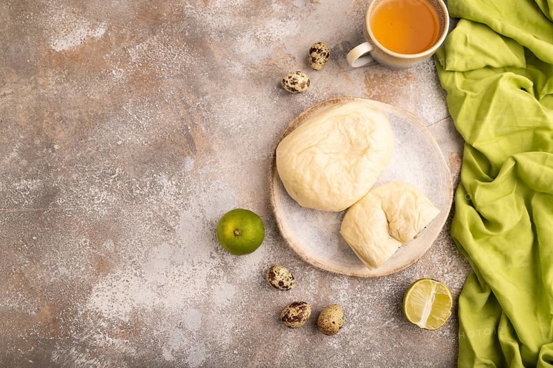 Vietnamese steamed buns Banh bao on brown concrete background and green linen textile. top view, flat lay, copy space