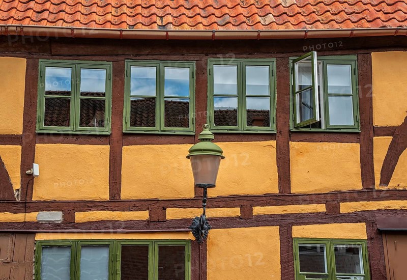 Part of the facade with windows and street lamp of an older half-timbered house in Ystad, Skåne County, Sweden, Scandinavia