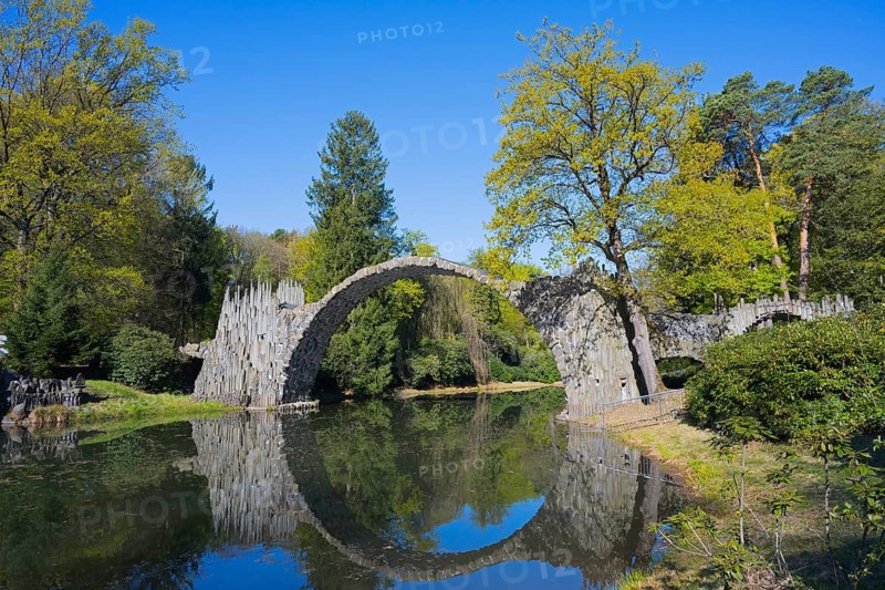 Majestic stone bridge and its reflection surrounded by green forest, Rakotz Bridge, Devil's Bridge, Rakotzsee, arched bridge, reflection, basalt organ, Kromlau, Görlitz district, Saxony, Germany