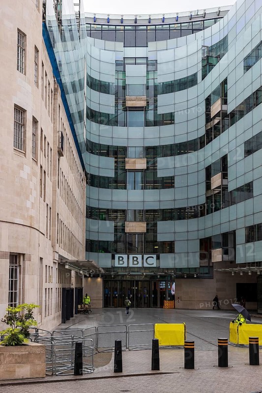 The curved glass extension of BBC Broadcasting House rises beside its original Portland stone building, London, England, United Kingdom