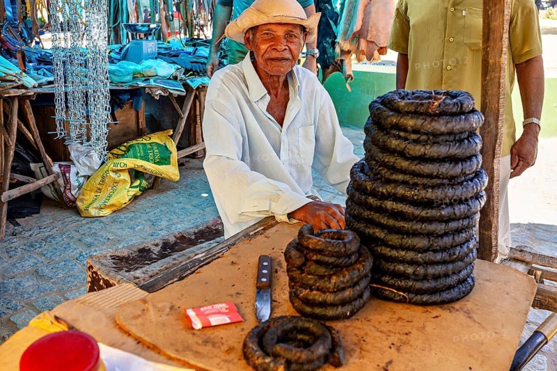 Elderly man behind displays with traditional products in a marketplace watching people, market scene in a small town in the Caatinga of Bahia and Pernambuco in Brazil