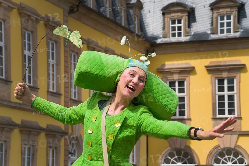 An artistic performance by a fairytale-like costumed stilt walker, visually impressive walking act, event in front of the Residenzschloss Arolsen, a baroque castle in Bad Arolsen, early 18th century, Hesse, Germany