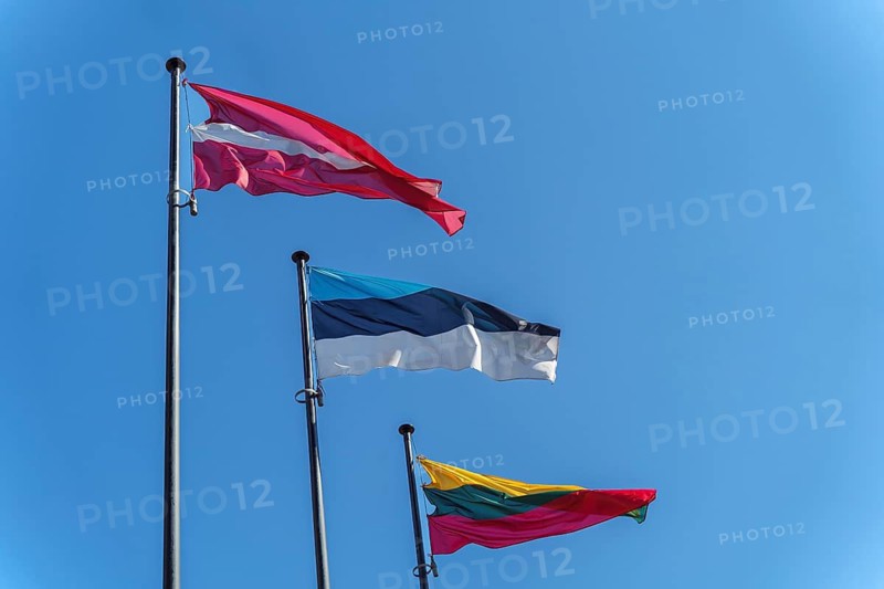 Latvian, Estonian and Lithuanian flags on flagpoles against blue clear sky, Three national flags of Latvia, Estonia, and Lithuania waving against a clear blue sky