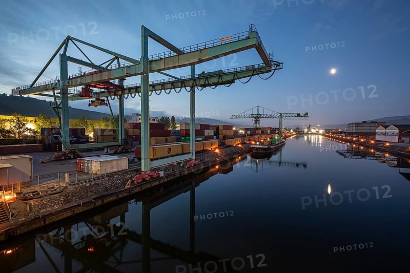8.5.2026: Container terminal at Stuttgart harbor with cranes and barge under moonlight. Stuttgart, Baden-Württemberg, Germany